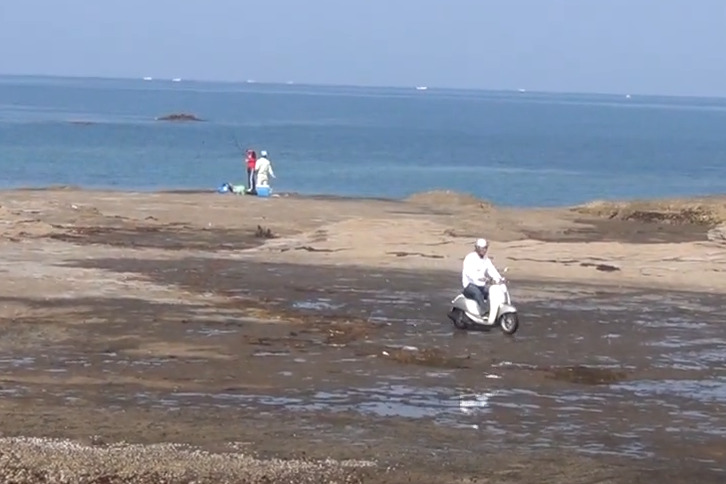 バイクで磯の上を走る釣り人。和歌山田辺元島地磯ゴデンマツ。釣太郎